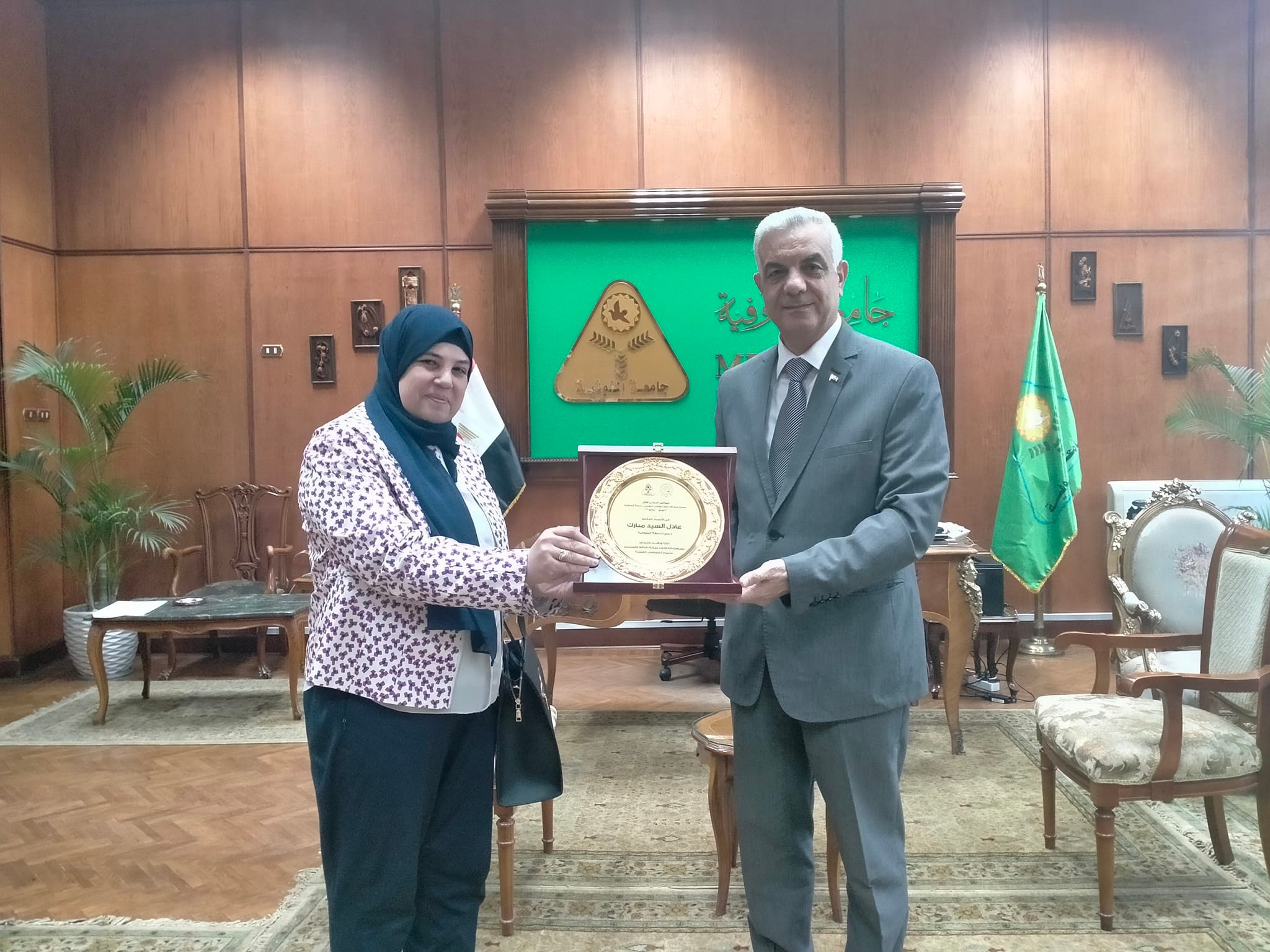 The shield of the first international conference of the Department of Psychiatry and Neurology is presented to the President of Menoufia University